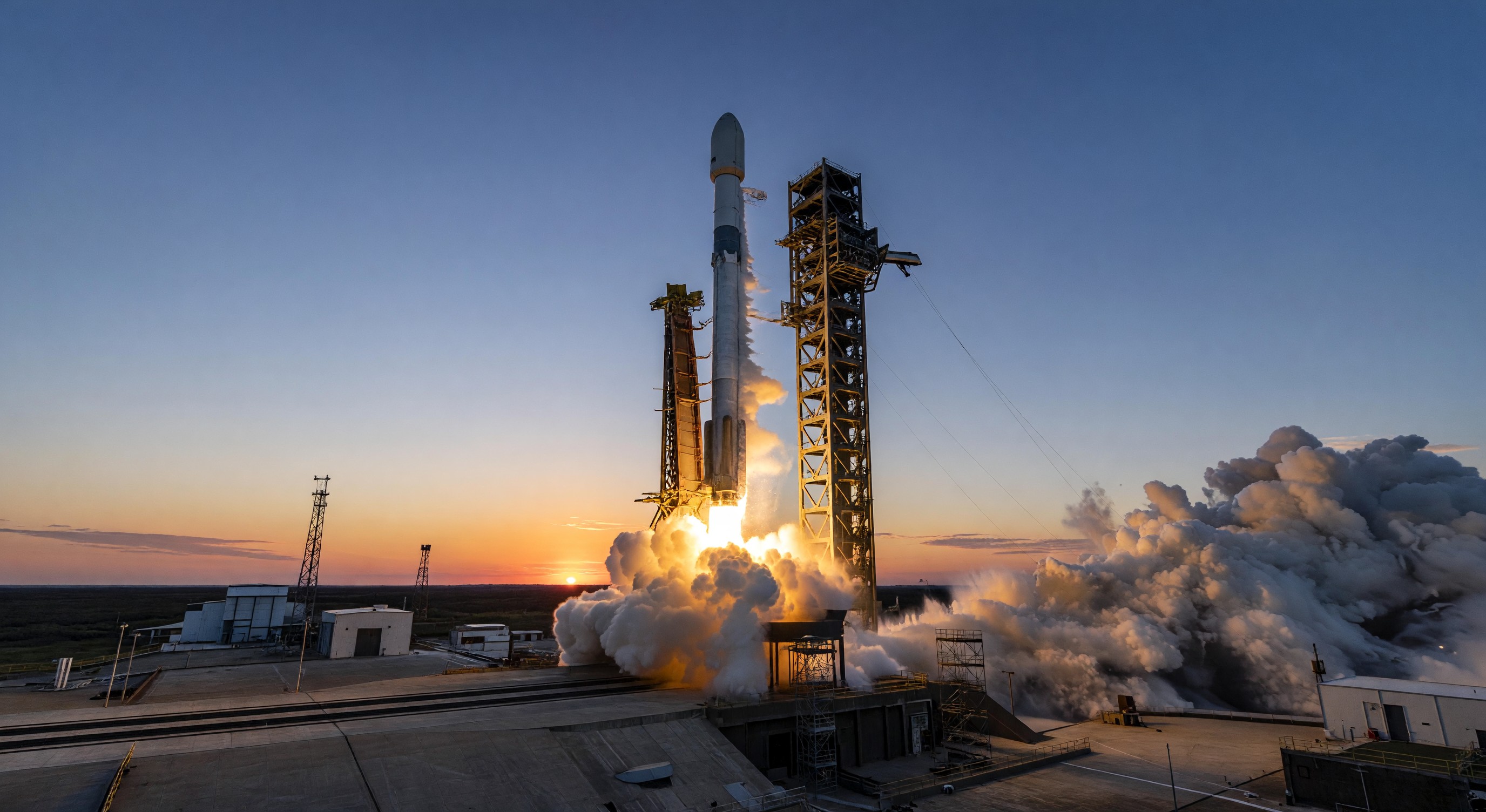 Launch vehicle on pad at sunrise with rocket exhaust plume