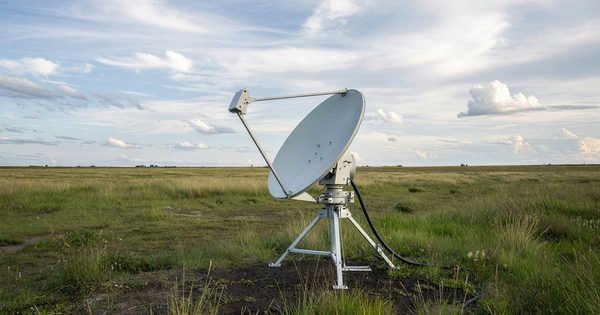 Satellite broadband terminal dish in rural field pointing at sky